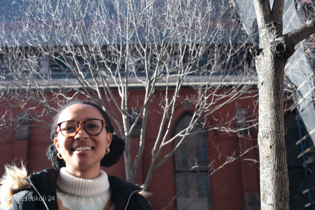 A smiling young black woman with sunlight on her face