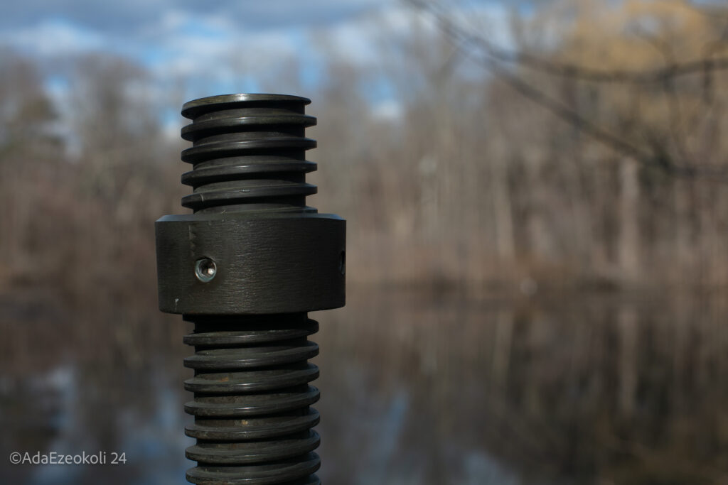 An iron railing is isolated from the lake behind it.