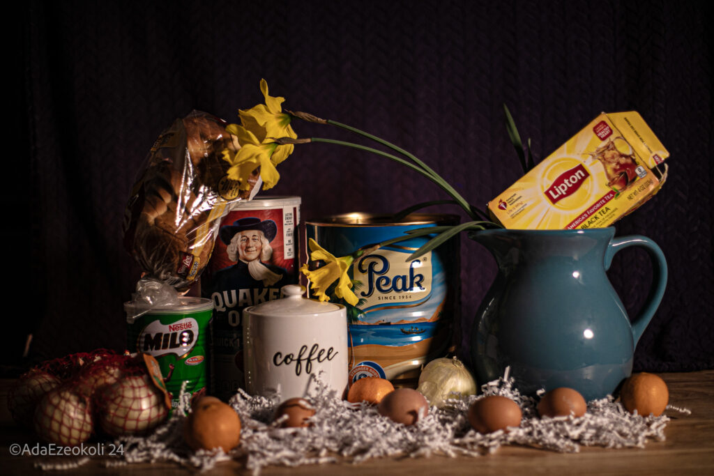 A vase with yellow flowers on a table with breakfast items common in Nigeria